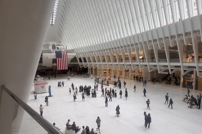Two large American flags hang from within The Oculus in the World Trade Center in downtown Manhattan on September 11, 2026. (Shalina Chatlani/ Stateline)