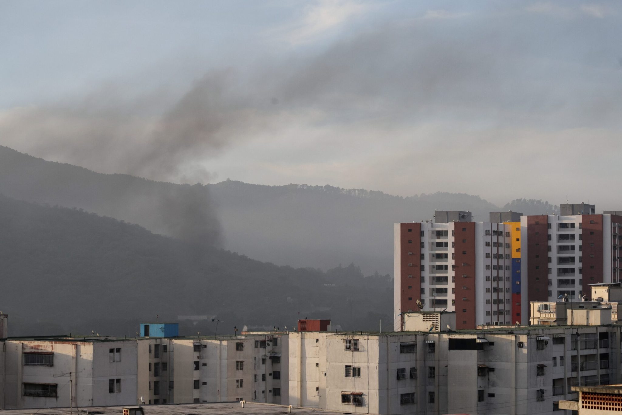 Smoke is seen over buildings after explosions and low-flying aircraft were heard on Jan. 3, 2026 in Caracas, Venezuela. (Photo by Jesus Vargas/Getty Images)