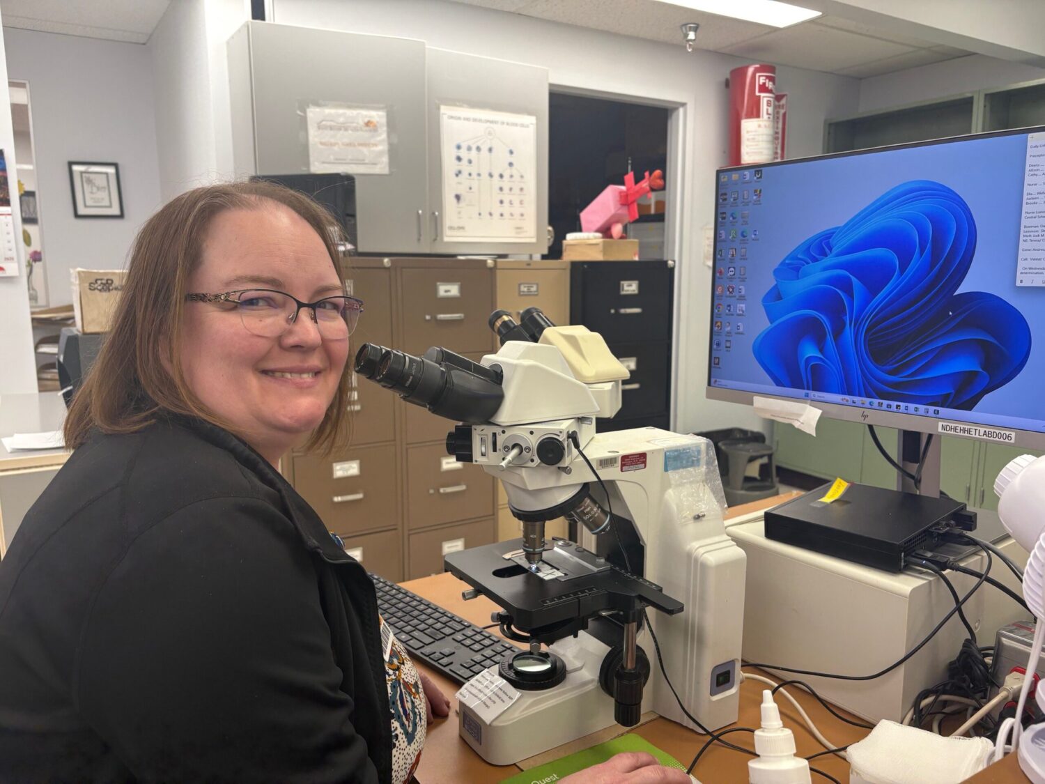 Bekki Holzkamm, lab manager at West River Health Services in rural North Dakota, has been trying to hire a technician since late summer. But not one U.S. citizen has applied. West River will have to pay a new $100,000 H-1B visa fee — or request an exemption — if it wants to hire one of its foreign applicants. (Kathrine Abelita)