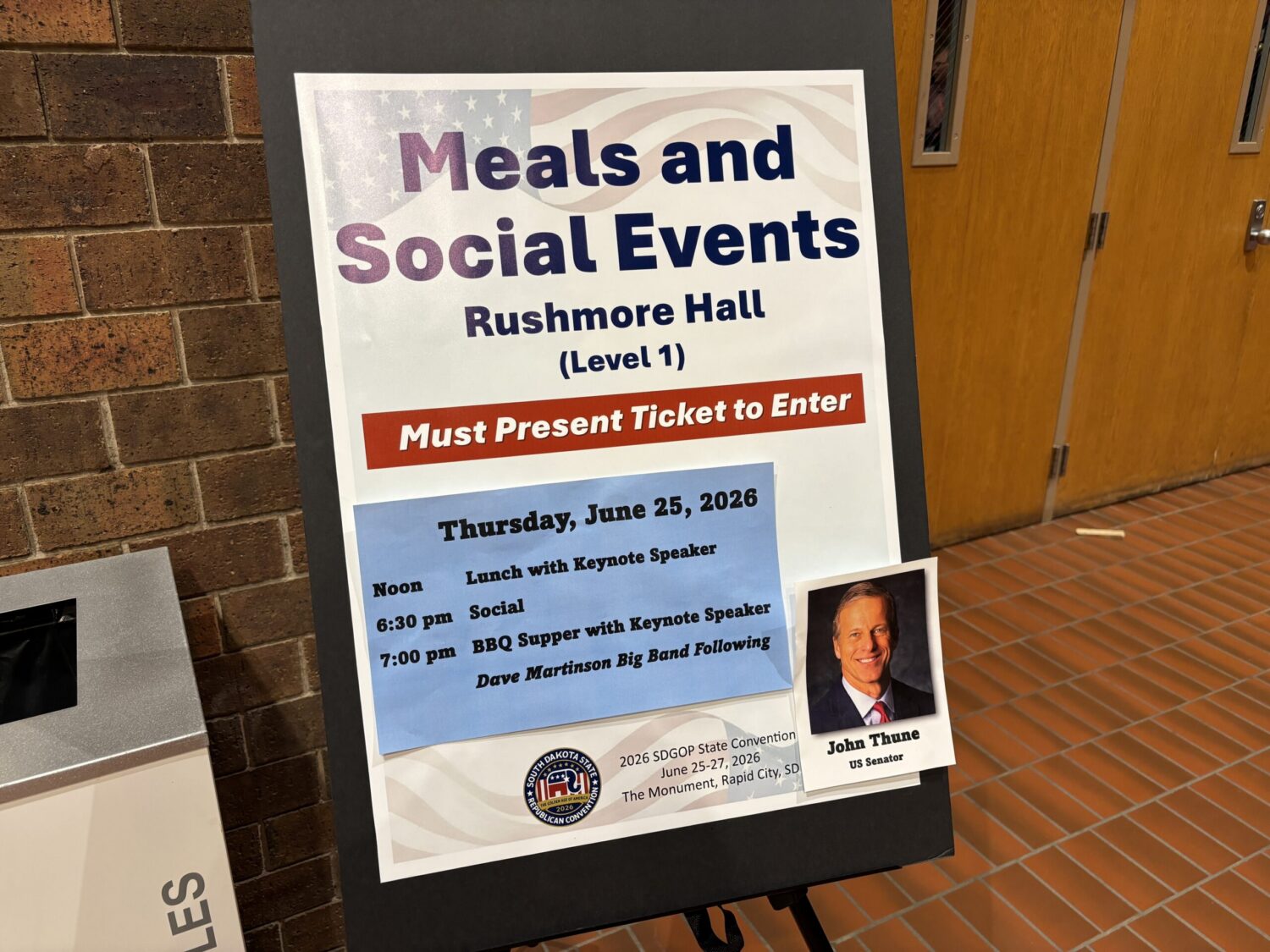 A sign outside Rushmore Hall at The Monument events center in Rapid City, South Dakota, advertises a keynote speech by U.S. Senate Majority Leader John Thune, R-South Dakota. Party officials denied South Dakota Searchlight entrance to the speeches after Searchlight completing a press registration and received a confirmation email. (Photo by Seth Tupper/South Dakota Searchlight)