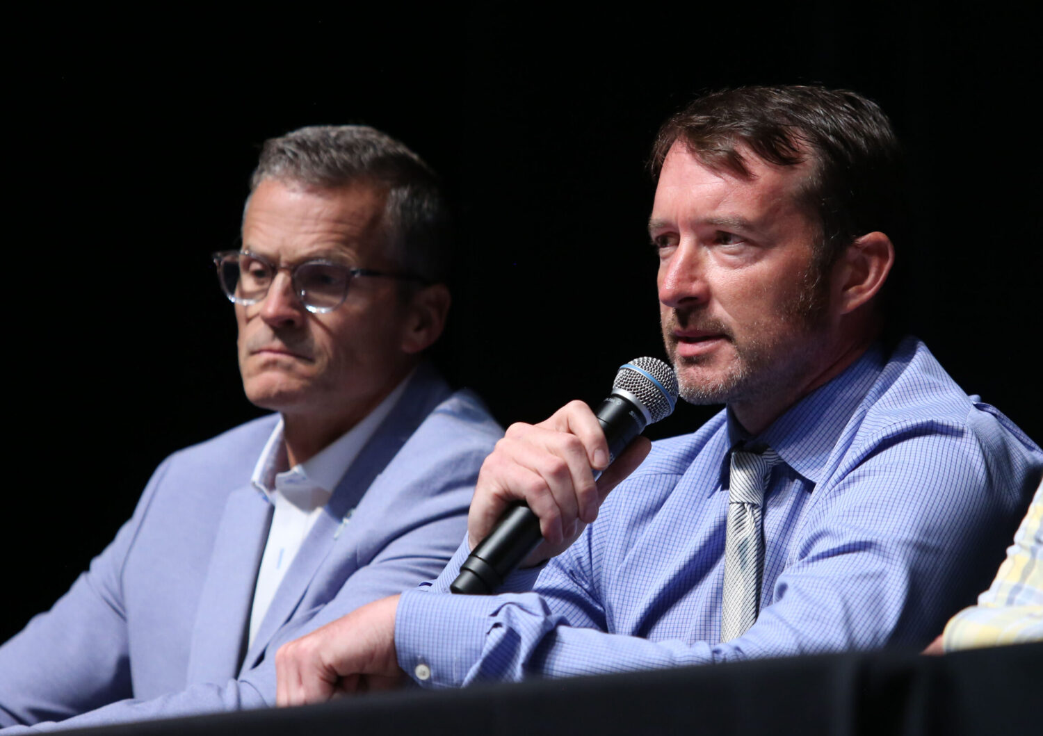 Sioux Falls Police Chief John Thum, right, speaks at a forum on July 22, 2025, in downtown Sioux Falls about the proposed construction of a men's prison in the northeastern part of the city. At left is Mayor Paul TenHaken. (Makenzie Huber/South Dakota Searchlight)