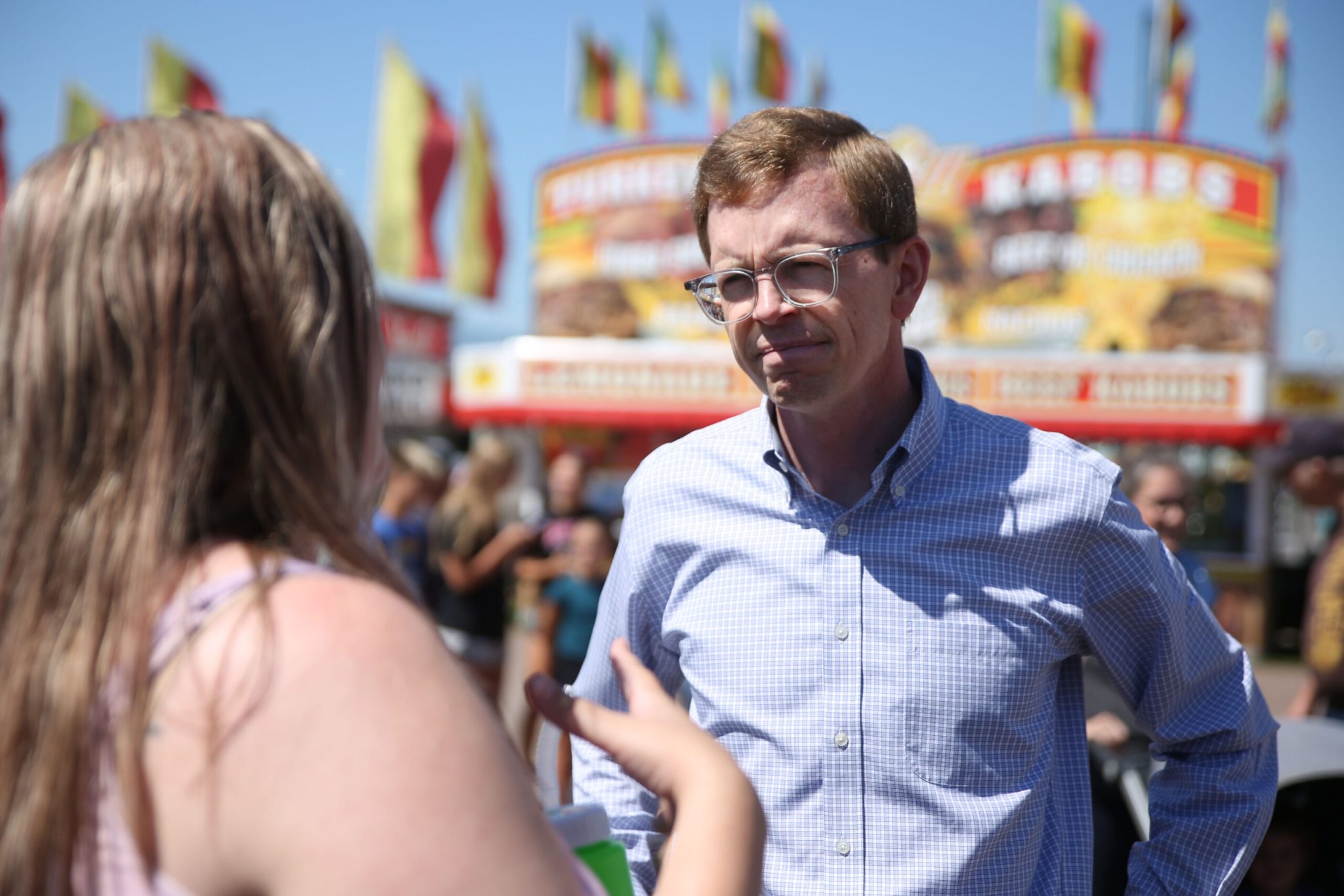 U.S. Rep. Dusty Johnson, R-S.D., speaks with a constituent at the Sioux Empire Fair in Sioux Falls on Aug. 5, 2026. (Photo by Makenzie Huber/South Dakota Searchlight)