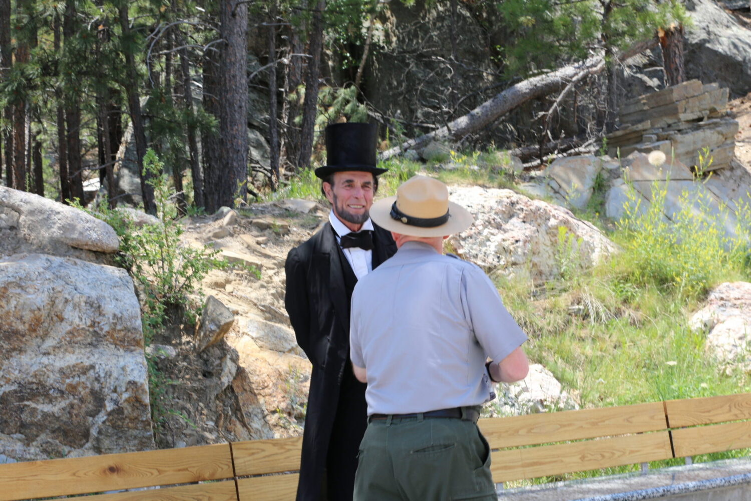Fritz Klein, left, has been impersonating President Abraham Lincoln for decades. He spoke with park rangers and guests at a Freedom 250 fireworks display at Mount Rushmore National Memorial on July 3, 2026. (Photo by Meghan O'Brien/South Dakota Searchlight)