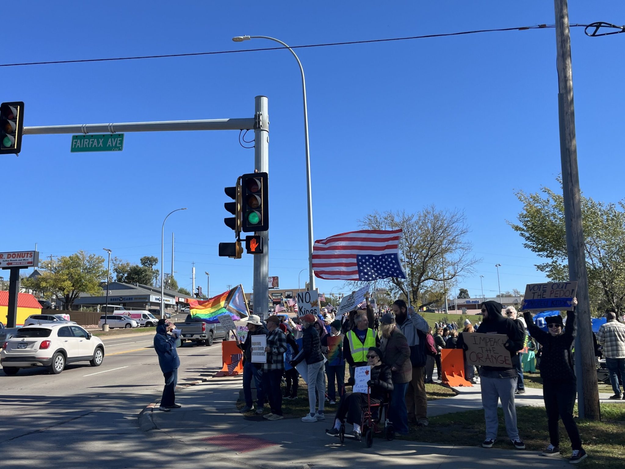 The No Kings demonstration in Sioux Falls on Oct. 17, 2026, was at Drake Springs Park near downtown. Demonstrators lined 10th Street along the park's borders. Speakers and a band took the stage to criticize the Trump administration and encourage advance voting. (Photo by Makenzie Huber/South Dakota Searchlight)