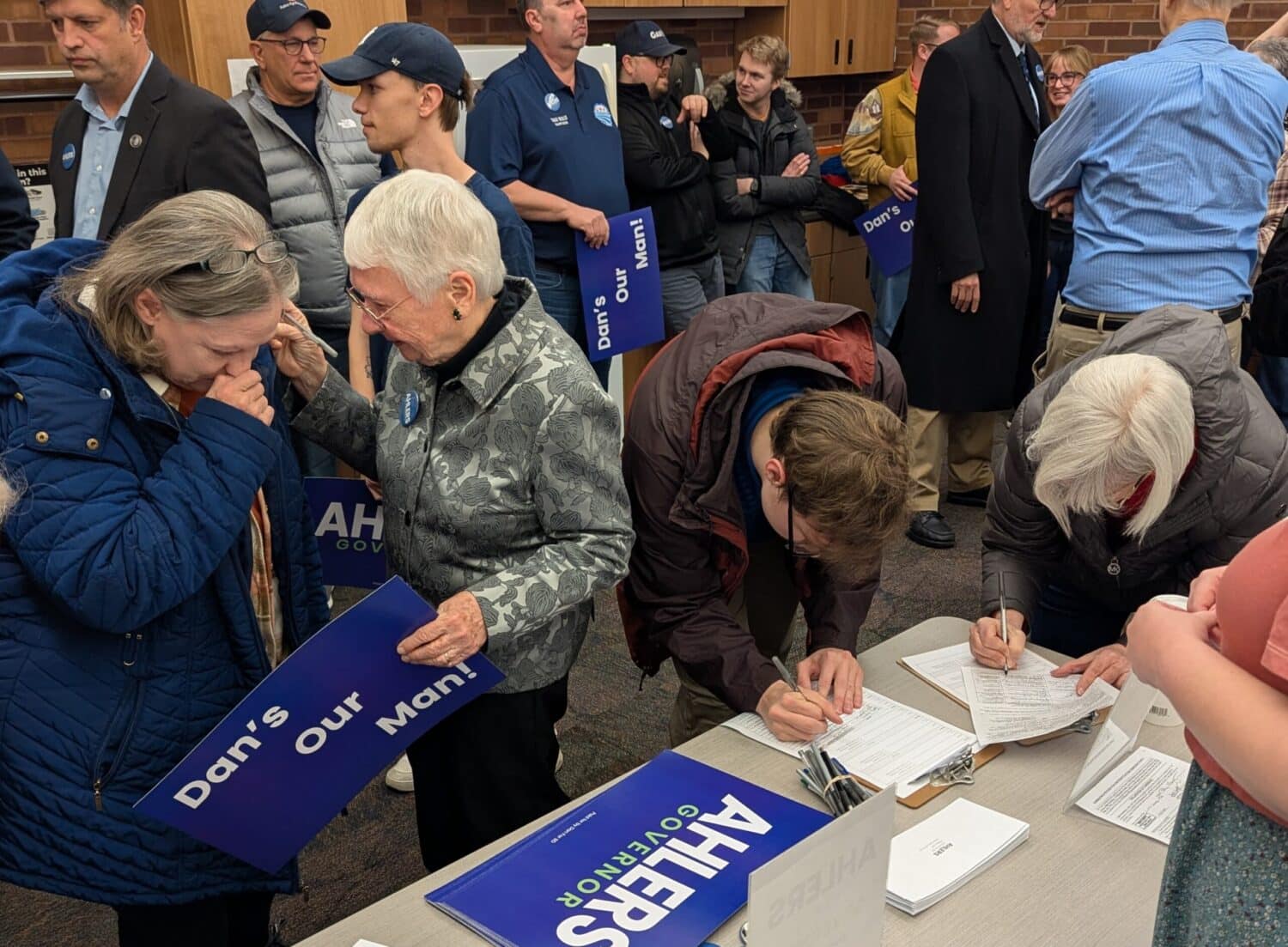 Voters sign nominating petitions for South Dakota Democratic gubernatorial candidate Dan Ahlers on Feb. 11, 2026, at the downtown library in Sioux Falls. (Photo by John Hult/South Dakota Searchlight)