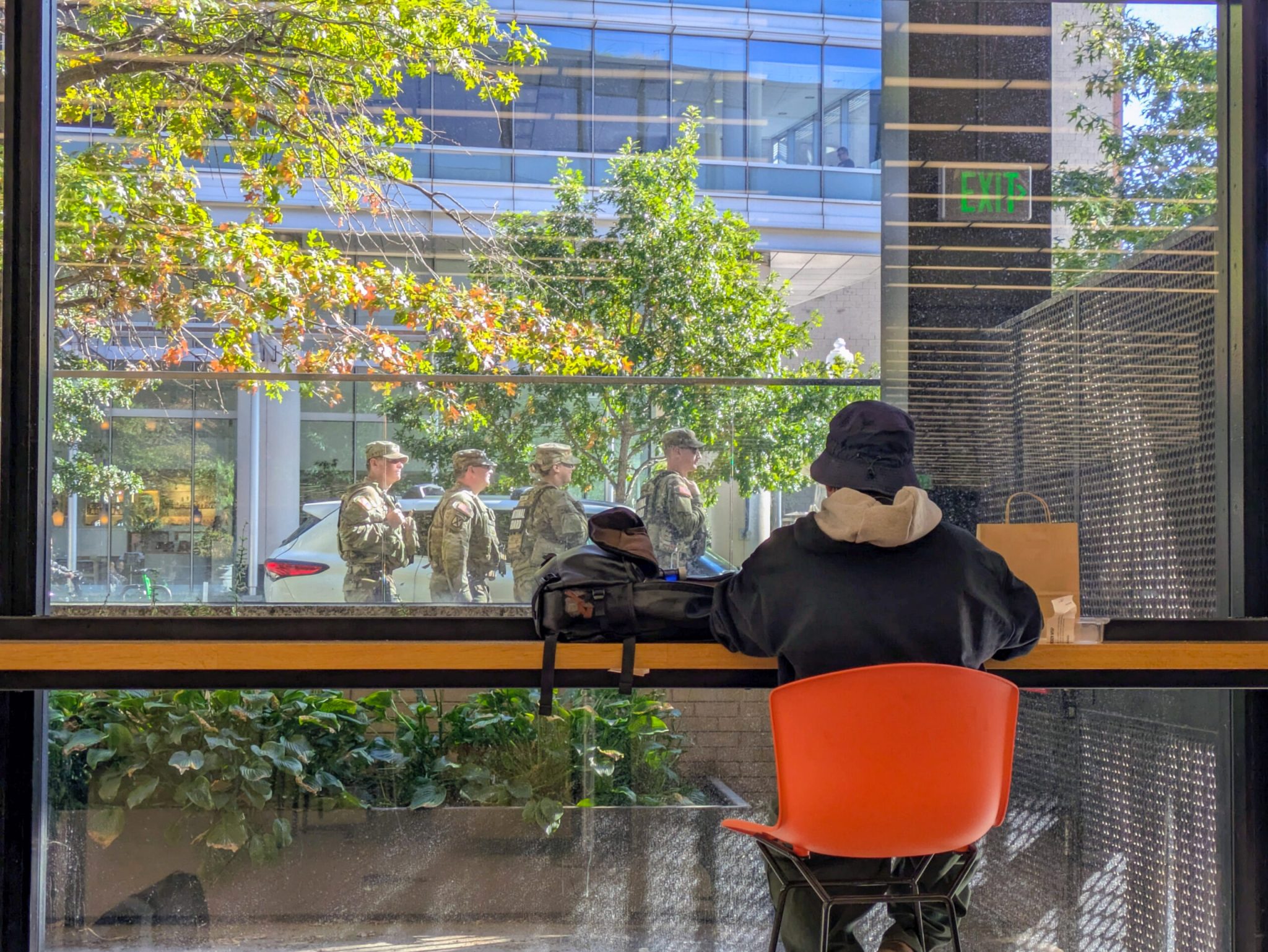 Patrons watch National Guard troops outside the windows of the Martin Luther King Jr. Memorial Library at G and 9th streets NW in Washington, D.C., on Tuesday, Oct. 21, 2025. (Photo by Ashley Murray/States Newsroom)