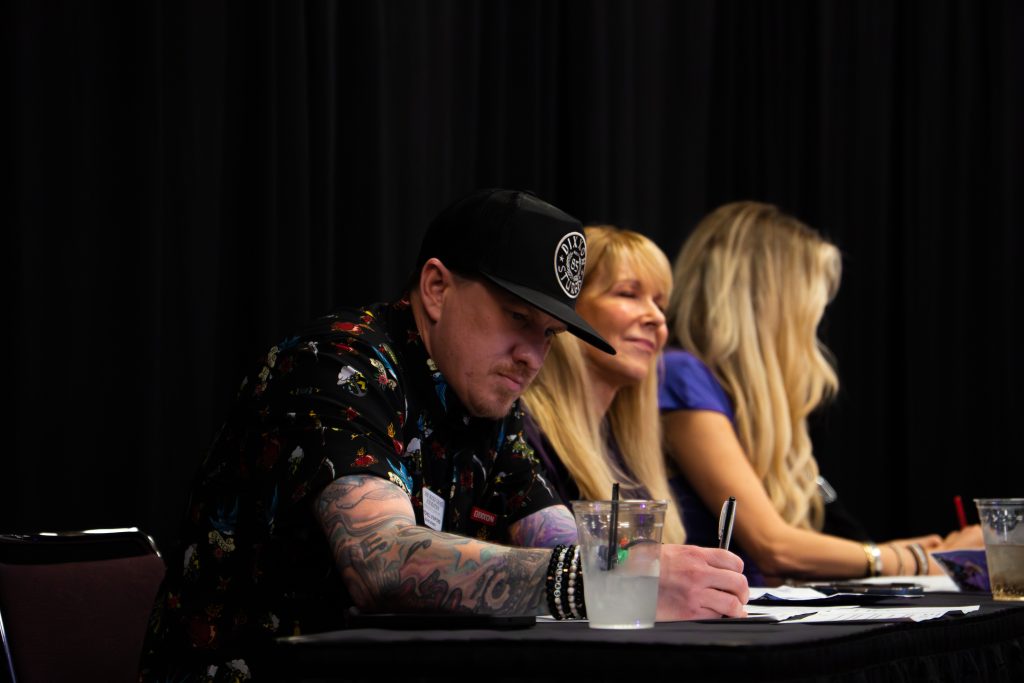 Pictured is Radio Host Stitch writing Judge feedback on a piece of paper. Photo by Ethan Huntley
