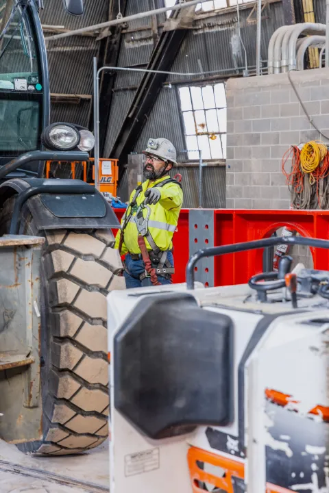 Technicians rig DUNE cryostat beams for loading into the cage.