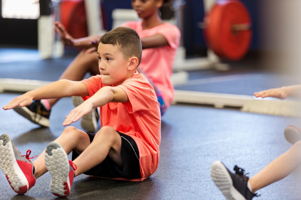 An elementary school student concentrates while performing a sit-up during physical education class. (Photo via Getty Images)